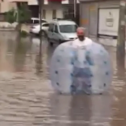 Mersin'de göle dönen caddede şişme balonla yüzdü: Muhtar öğrenciyi omzunda taşıdı