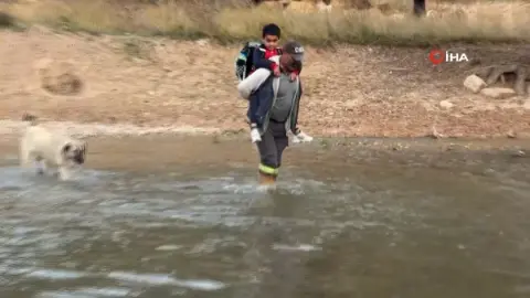 Oğlunu okula gönderebilmek için her gün sırtına alıp ırmaktan geçiriyor