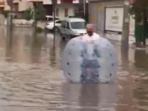 Mersin'de göle dönen caddede şişme balonla yüzdü: Muhtar öğrenciyi omzunda taşıdı