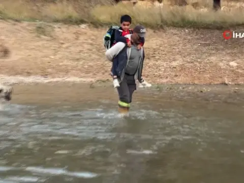 Oğlunu okula gönderebilmek için her gün sırtına alıp ırmaktan geçiriyor