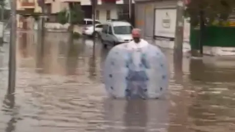 Mersin'de göle dönen caddede şişme balonla yüzdü: Muhtar öğrenciyi omzunda taşıdı