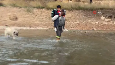Oğlunu okula gönderebilmek için her gün sırtına alıp ırmaktan geçiriyor