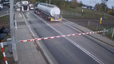 Polonya'da hemzemin geçitte mahsur kalan tanker az kalsın trenin altında kalıyordu