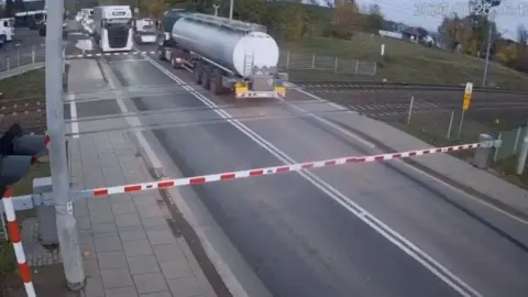 Polonya'da hemzemin geçitte mahsur kalan tanker az kalsın trenin altında kalıyordu